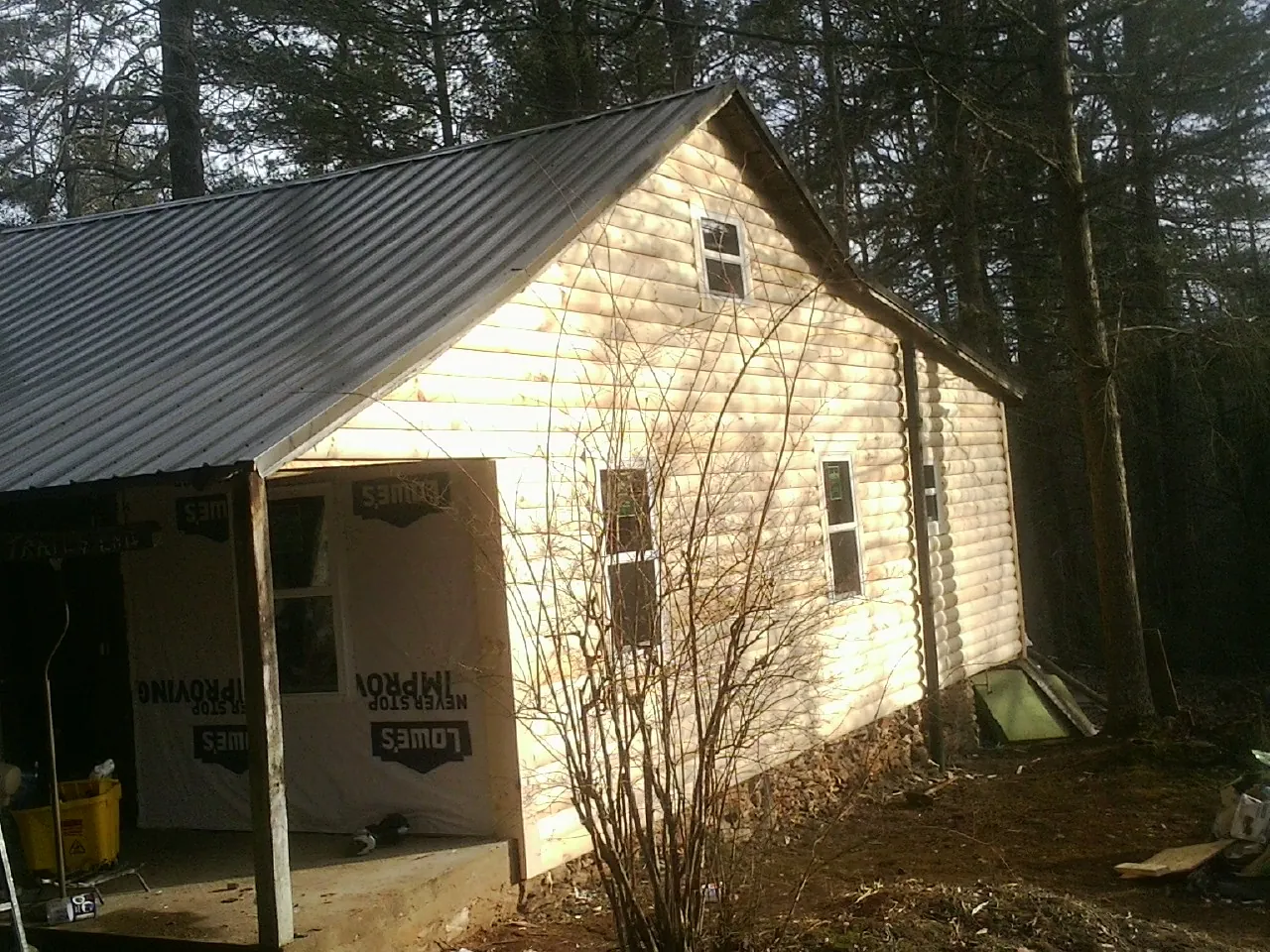 Log siding gable end under a dark metal roof edge in Beverly